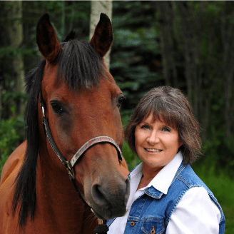 Dark-haired woman standing next to brown horse